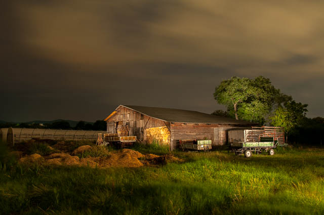 Mit Langzeitbelichtung bei Nacht fotografierter Stadl am Land.